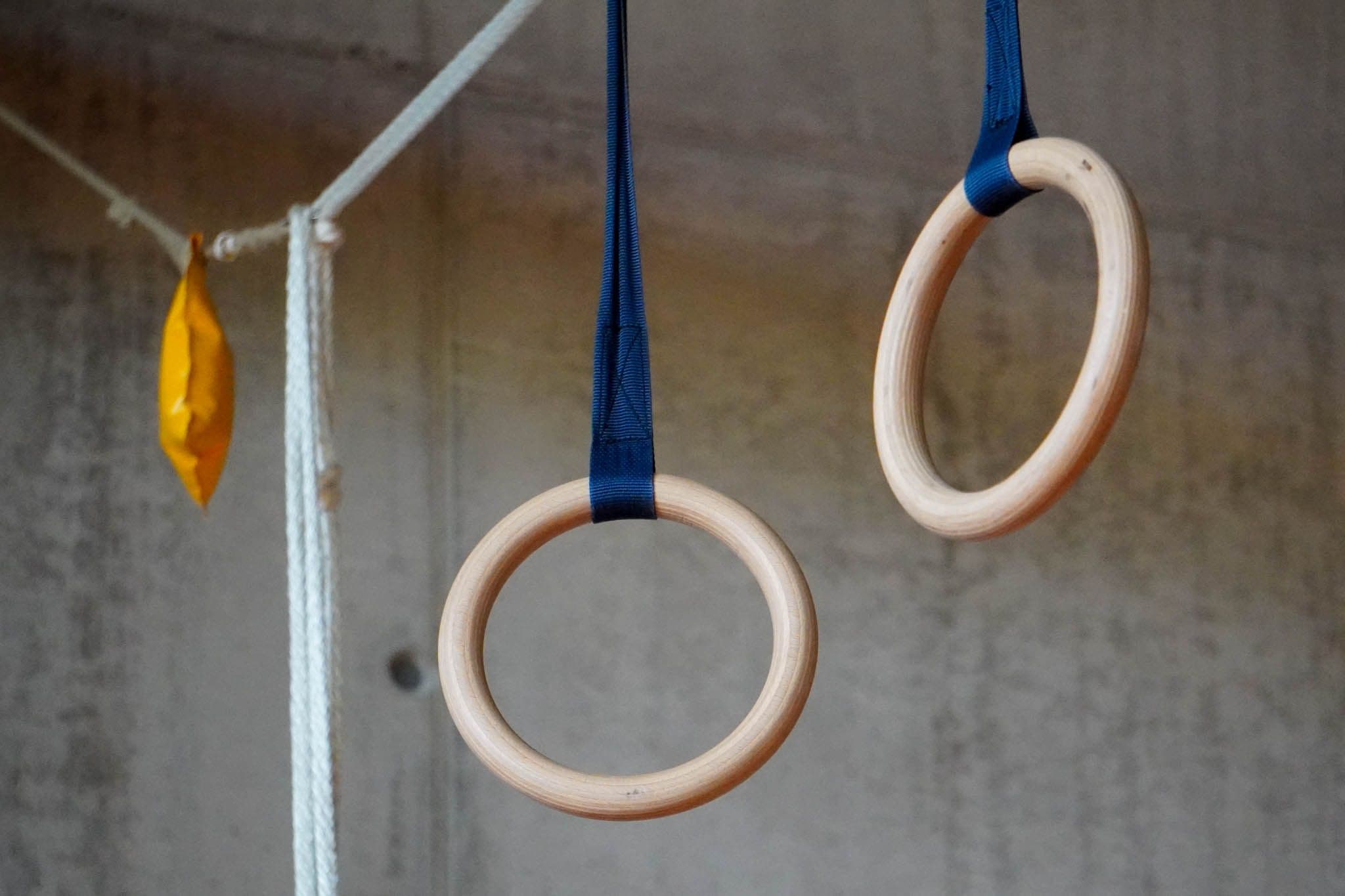 Zwei hängende Holzringe in einer Turnhalle.