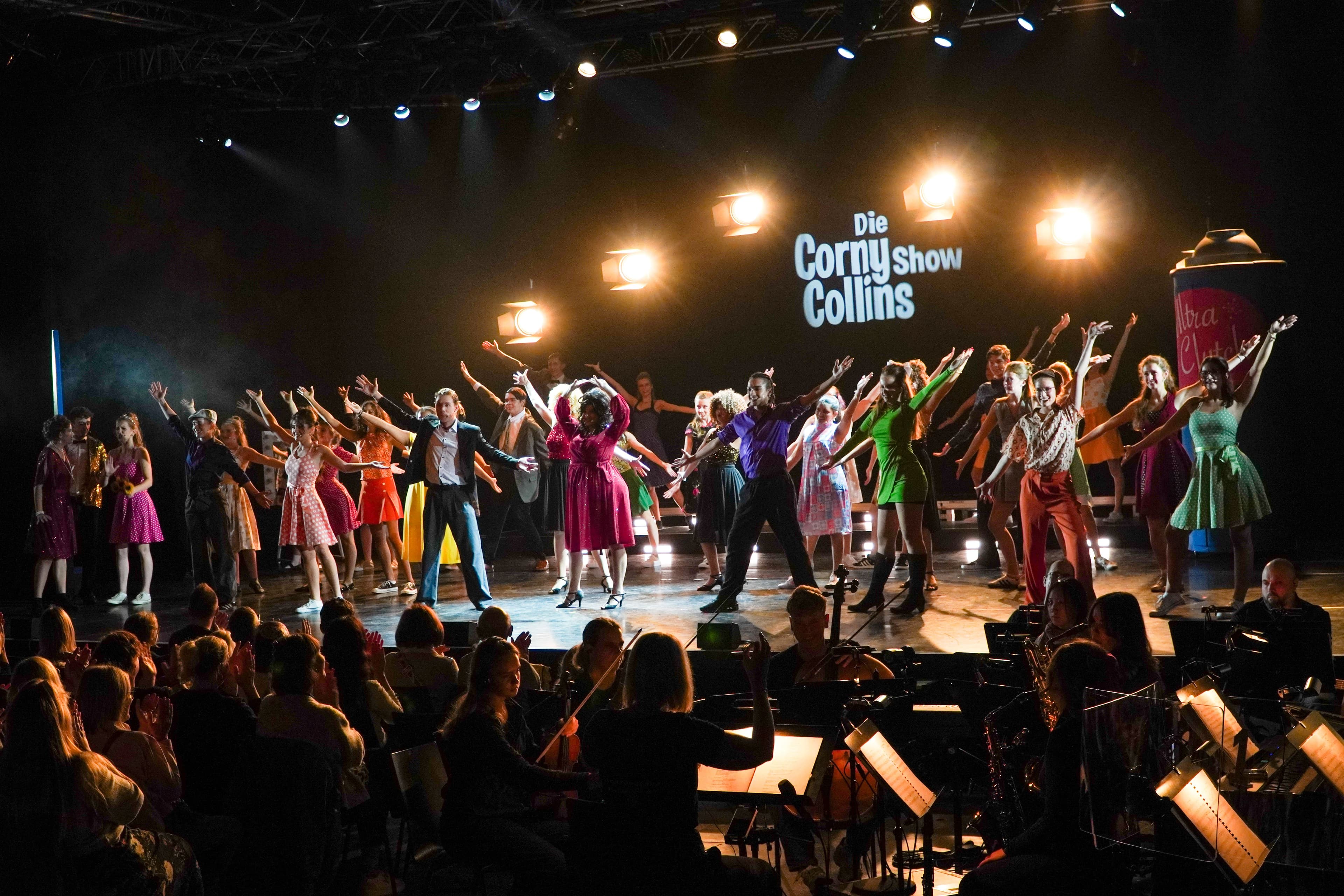 Schauspieler in bunten Kostüme auf einer Bühne.