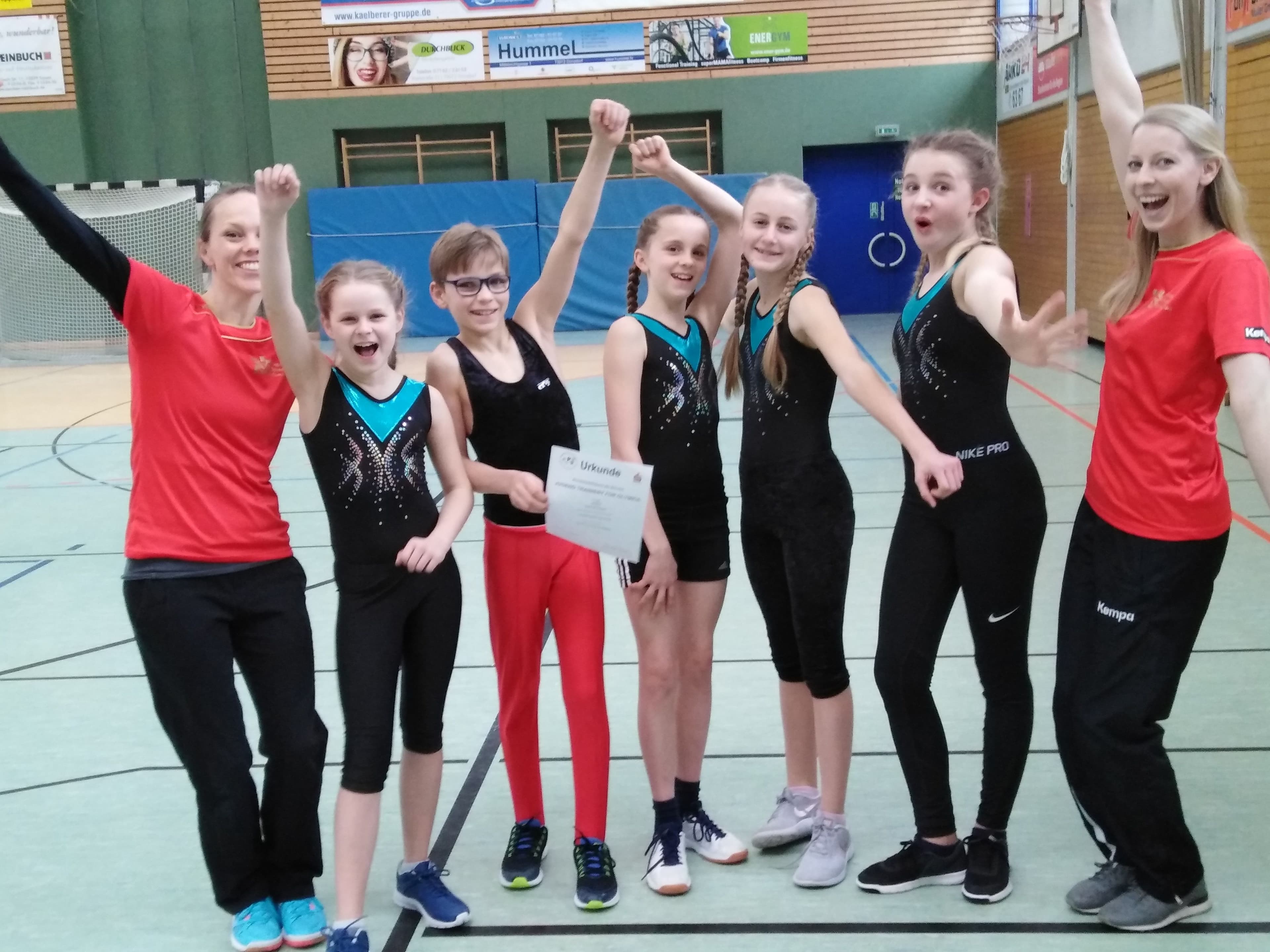 Jubelndes Turnteam bei einem Wettkampf.