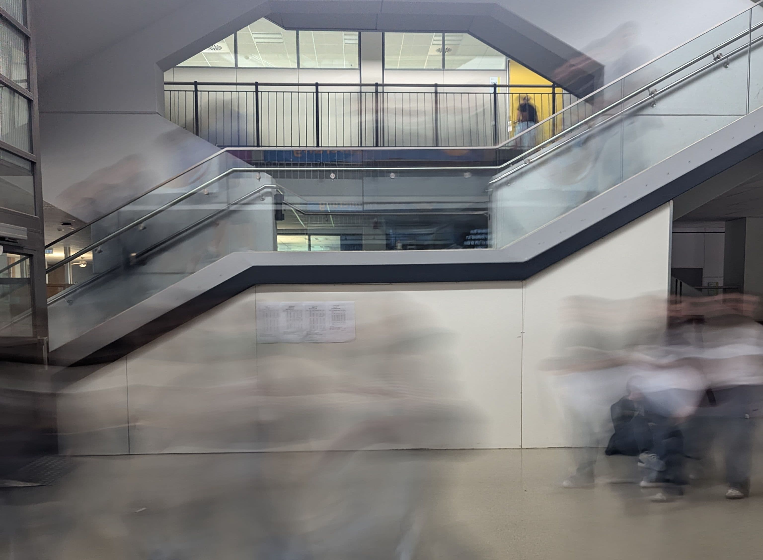 a blurry picture of people walking down stairs in a building