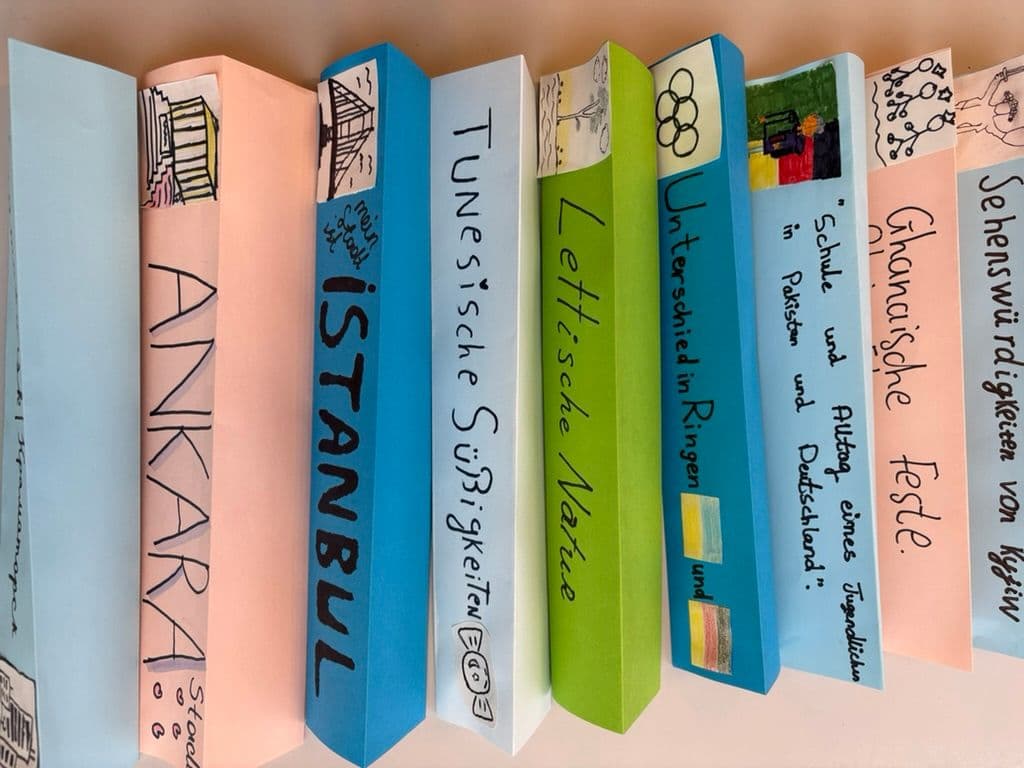 Colorful, handmade book spines featuring titles and drawings about various countries and cultures.