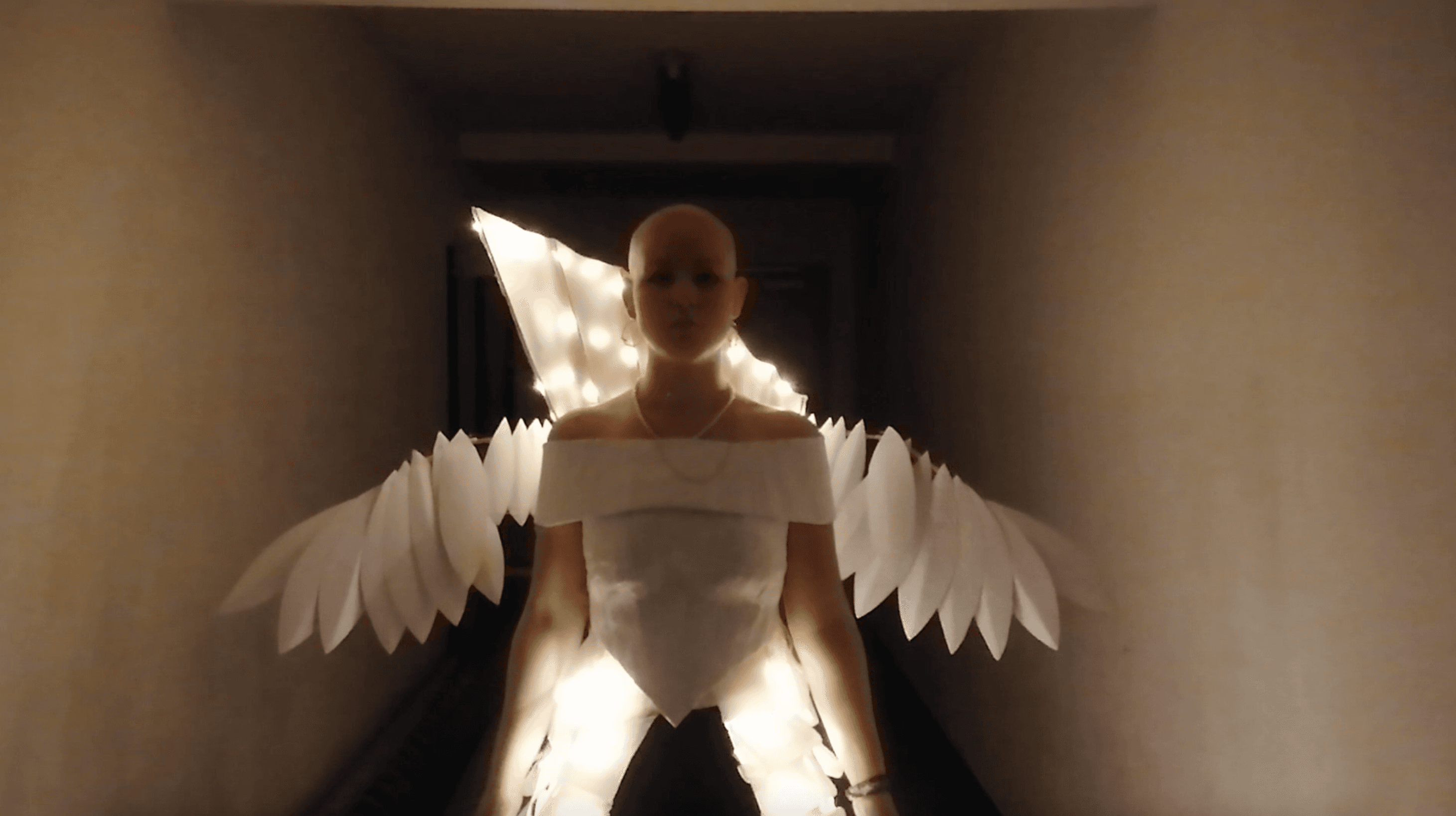 ein von hinten beleuchteter Mensch mit Engelsflügeln