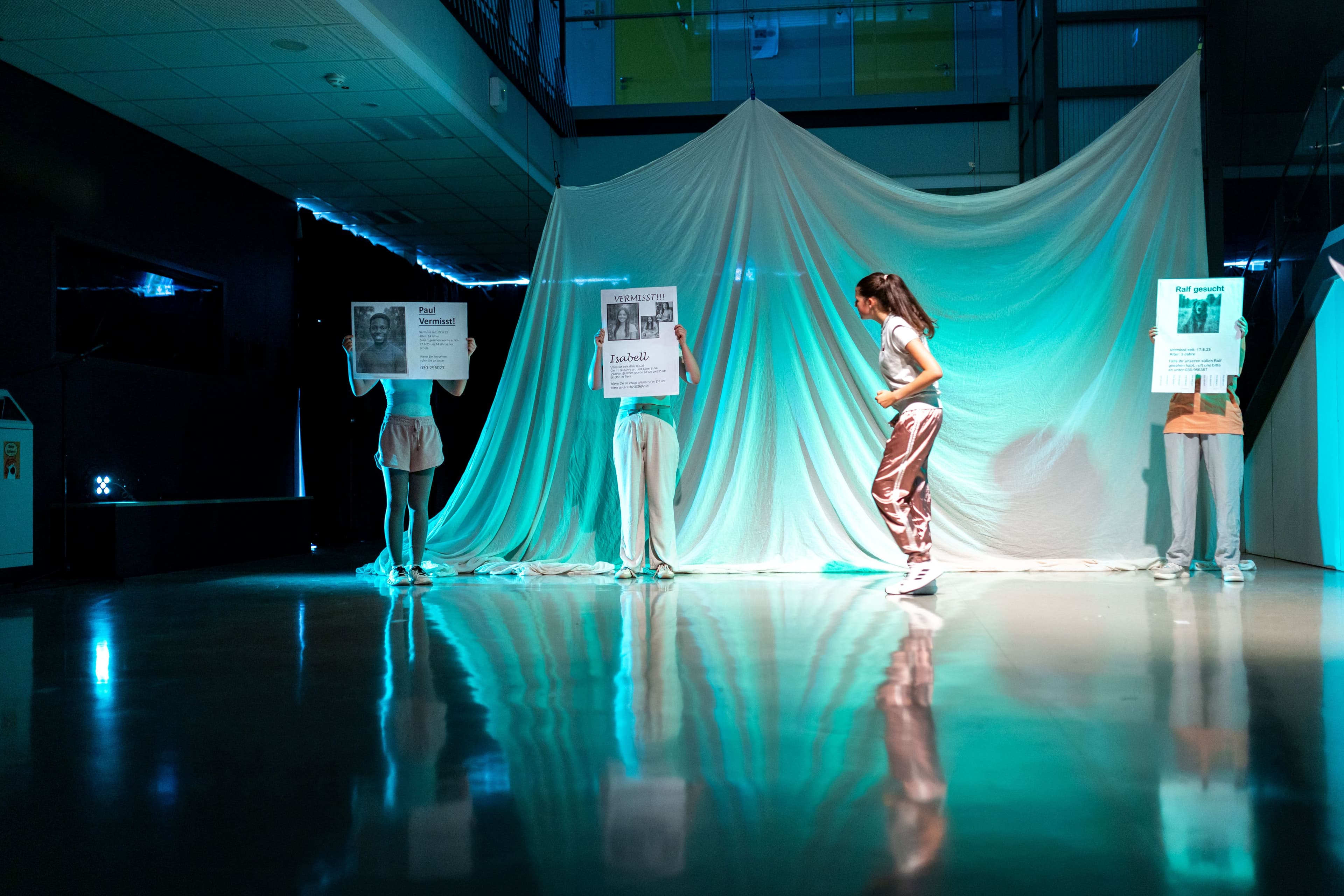 a group of people are standing on a stage holding signs .