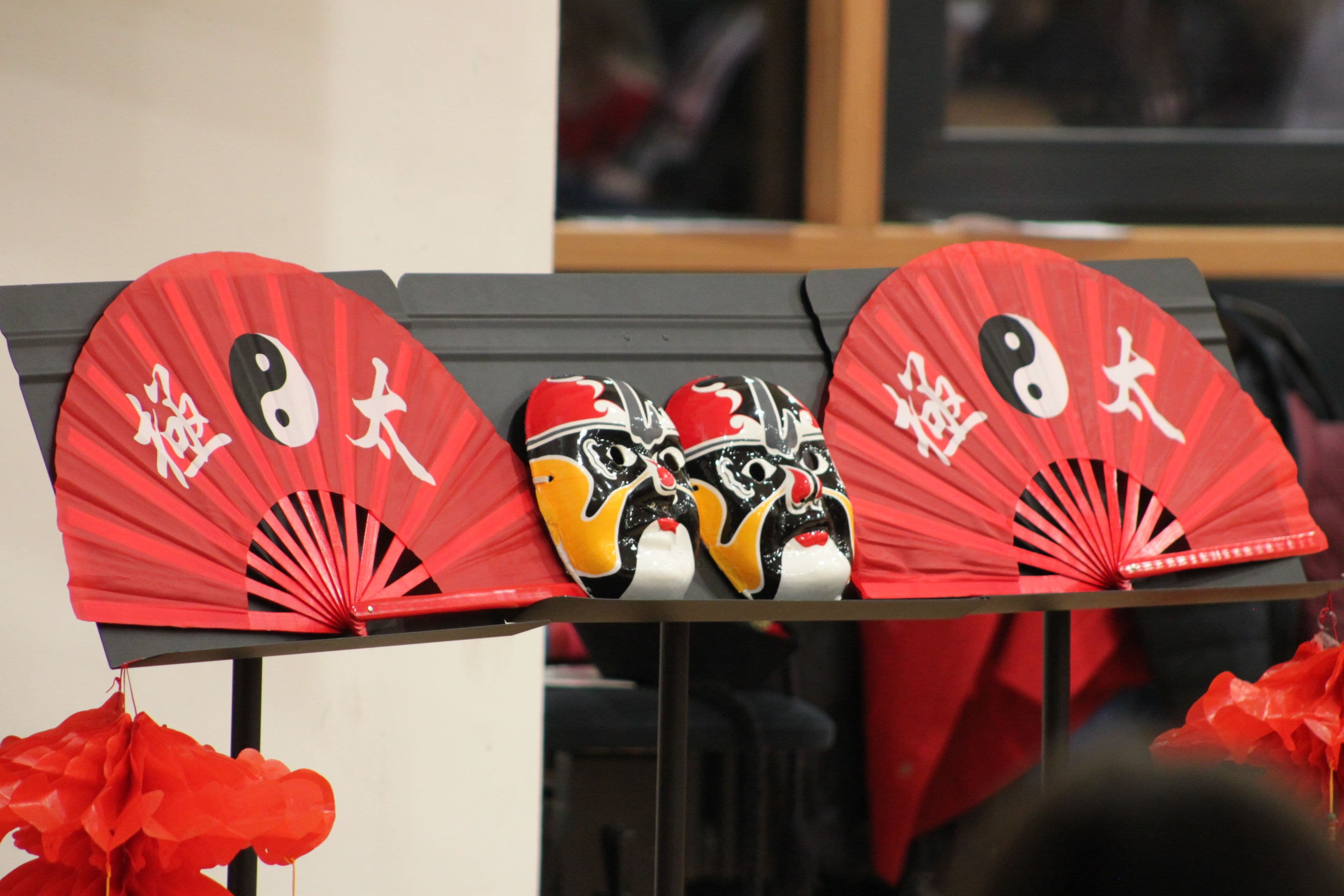 three red fans with chinese characters on them are sitting on a table .