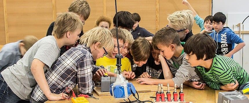 Eine Gruppe Kinder blickt auf eine Verkabelung