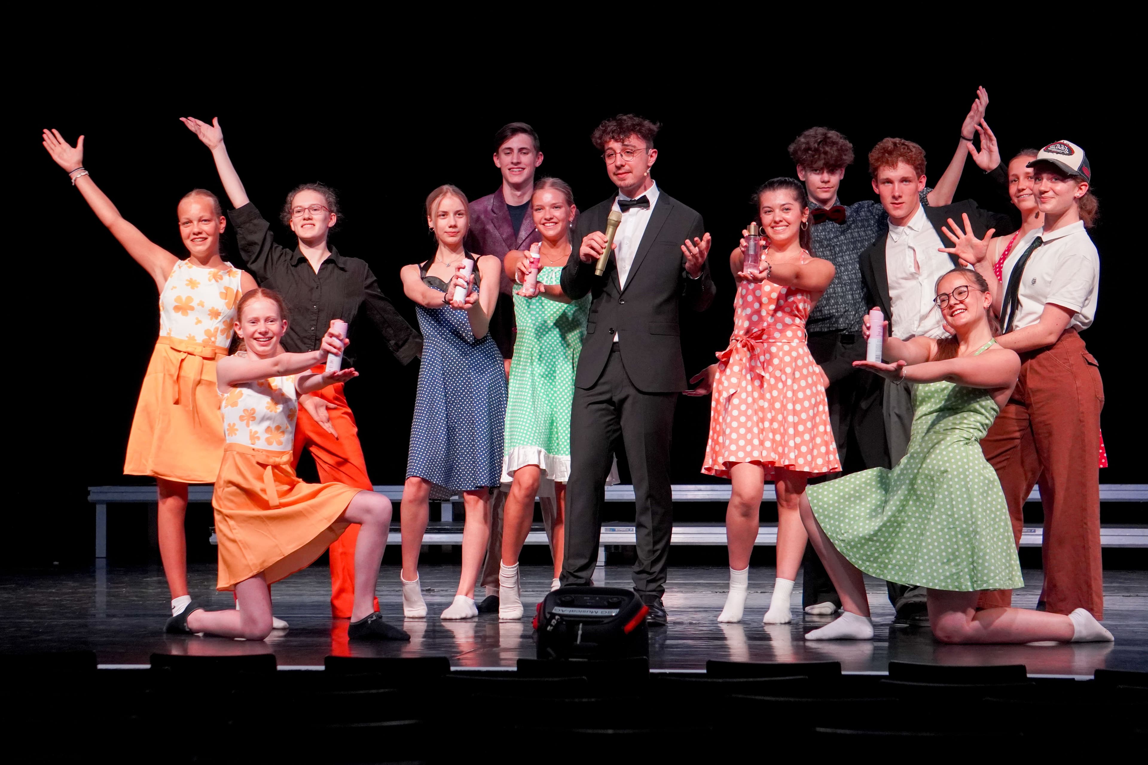 Schüler posieren in Kostümen bei einer Tanzprobe des Musicals "Hairspray"