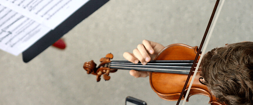 Geigenspieler mit Notenblatt von oben fotografiert