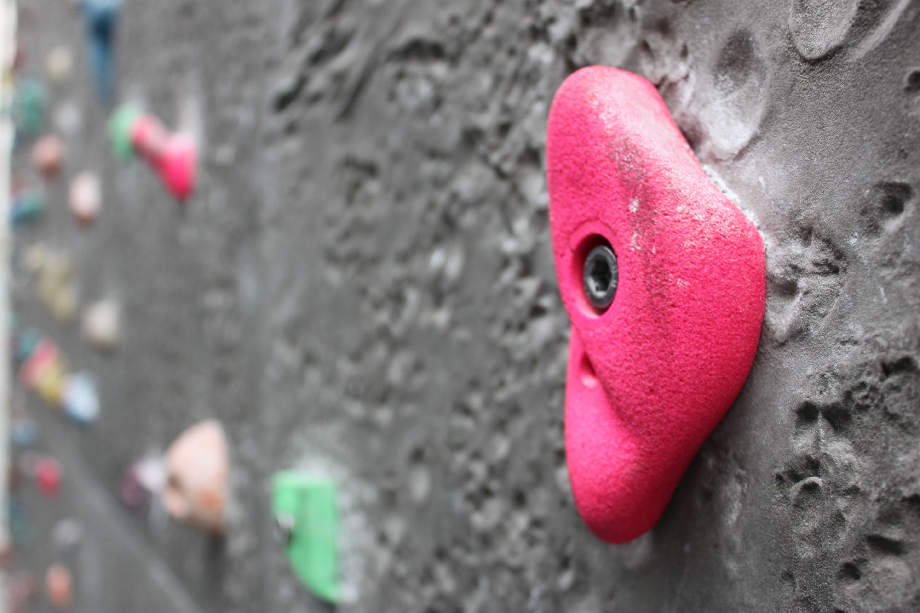 a close up of a red rock on a climbing wall .