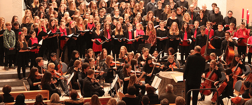 Bühne mit Menschen: Weihnachtskonzert mit Chor und Streichorchester